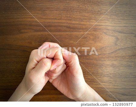 一個女人的手在桌上握緊拳頭 132893977