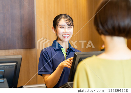 一位在健身房前台工作的年輕女員工。照片由Sports Club & Sauna Spa Renaissance Makuhari 24提供。 一位在健身房前台工作的年輕女員工。照片由Sports Club & Sauna Spa Renaissance Makuhari 24提供。 132894328