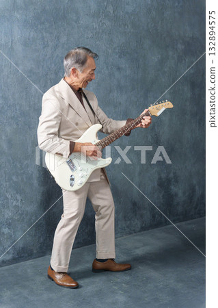 一位老人在彈電吉他 132894575