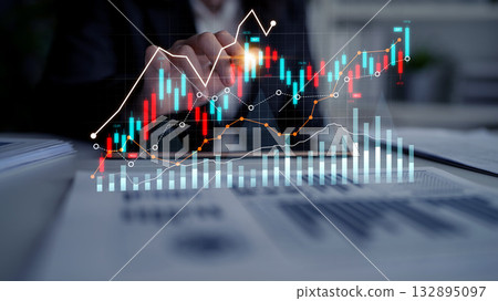 Businessman Analyzing Financial Data and Stock Market Trends with Digital Charts and Graphs Showing Growth and Fluctuations on a Desk in Office Environment Scalp 132895097