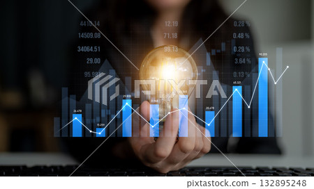 Businessman Holding Light Bulb with Graph and Chart Background Representing Ideas for Innovations and Growth in Financial Market Analysis Scalp 132895248