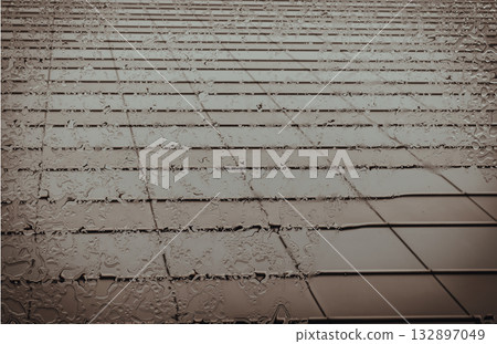 From below, the glass awning glistens, a cascade of raindrops tracing its surface. 132897049
