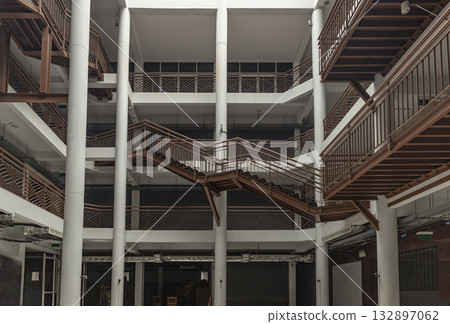 the interior of the Napa Building at Wongwian Yai. The building's design features a contemporary architectural style with a complex arrangement of crisscrossing steel staircases and railings the interior of the Napa Building at Wongwian Yai. The building's design features a contemporary architectural style with a complex arrangement of crisscrossing steel staircases and railings 132897062