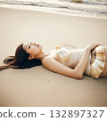 young woman lying on the beach 132897327
