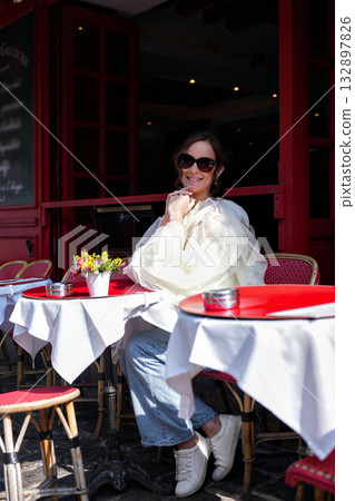 Woman sitting at Paris street cafe on sunny day 132897826