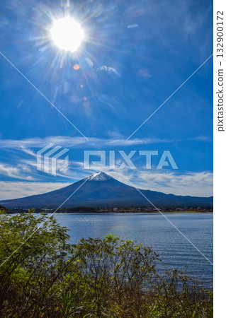 Clear autumn sky and clouds seen from Lake Kawaguchiko with the sun shining above the lake 132900172