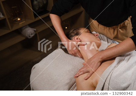 Relaxing neck and shoulder massage at a wellness spa in the afternoon for soothing stress relief and enhancing relaxation Relaxing neck and shoulder massage at a wellness spa in the afternoon for soothing stress relief and enhancing relaxation 132900342