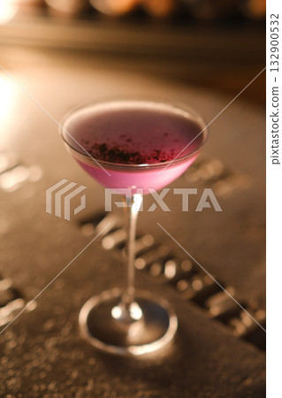 Colorful cocktail served in elegant glass highlights the vibrant atmosphere of a trendy bar at night 132900532
