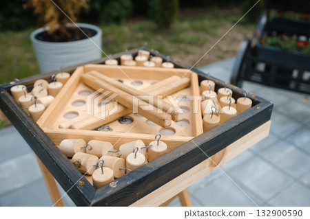 Wooden tabletop game with pieces ready for play in a sunny backyard setting during a summer afternoon gathering Wooden tabletop game with pieces ready for play in a sunny backyard setting during a summer afternoon gathering 132900590