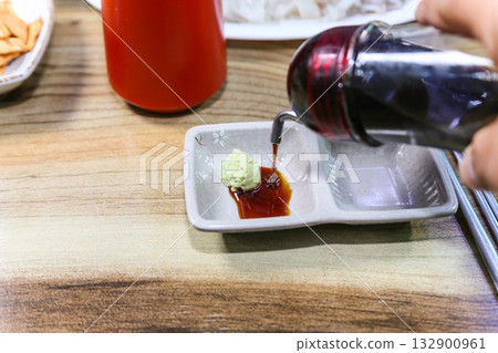 Pour Korean soy sauce into a bowl with wasabi Pour Korean soy sauce into a bowl with wasabi 132900961