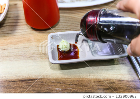 Pour Korean soy sauce into a bowl with wasabi Pour Korean soy sauce into a bowl with wasabi 132900962