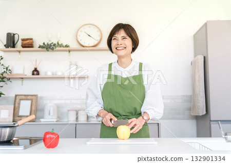 Senior Asian woman cooking in the kitchen at home (cut, cutting board, chopping) 132901334