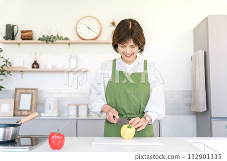 Senior Asian woman cooking in the kitchen at home (cut, cutting board, chopping) 132901335