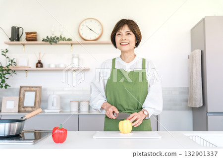 Senior Asian woman cooking in the kitchen at home (cut, cutting board, chopping) 132901337