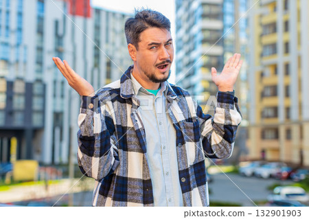 Doubtful sad frustrated mature Caucasian man shrugging shoulders dont know answer on city street 132901903