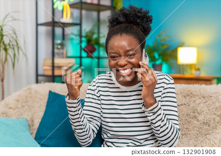 African American woman smiling gesturing during positive phone conversation talk holding smartphone 132901908