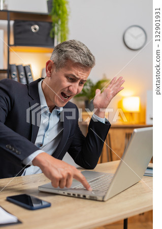 Frustrated Caucasian young entrepreneur having software problems with laptop at home office desk 132901931
