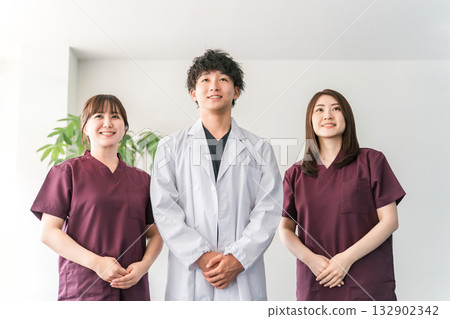 Male and female medical staff including doctors, nurses and doctors wearing white coats and scrubs Male and female medical staff including doctors, nurses and doctors wearing white coats and scrubs 132902342