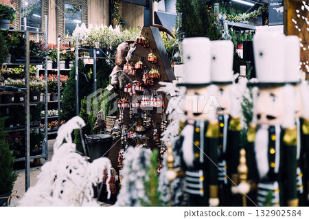 Indoor garden center transformed into a festive Christmas shop with nutcrackers, ornaments, and seasonal plants. Christmas retail display, holiday garden center, seasonal merchandising Indoor garden center transformed into a festive Christmas shop with nutcrackers, ornaments, and seasonal plants. Christmas retail display, holiday garden center, seasonal merchandising 132902584