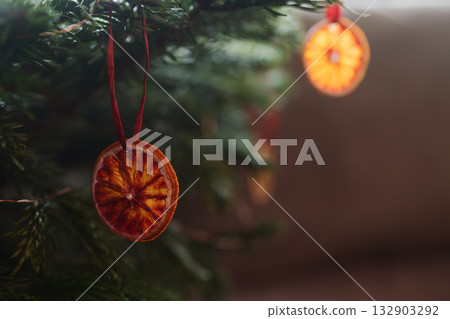 Closeup small christmas tree with dried oranges as decorations for holidays Closeup small christmas tree with dried oranges as decorations for holidays 132903292