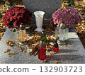 Flowers and candlelits on a tombstone in the public cemetery 132903723