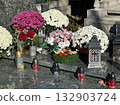 Flowers and candlelits on a tombstone in the public cemetery 132903724