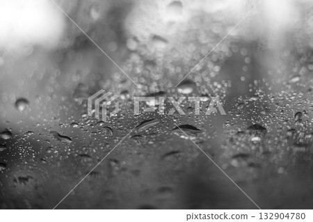 Water droplets on a car window, monochrome 132904780