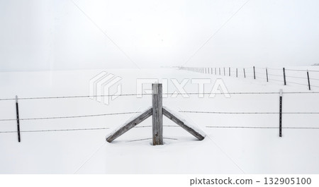 Minimalist Winter Fence Post in Deep Snow with Barbed Wire and Buried Split Rail Fencing Composition Minimalist Winter Fence Post in Deep Snow with Barbed Wire and Buried Split Rail Fencing Composition 132905100