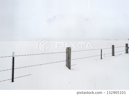 Minimalist Winter Fence Post in Deep Snow with Barbed Wire and Buried Split Rail Fencing Composition 132905101