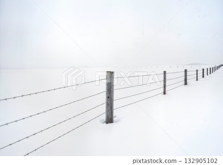 Minimalist Winter Fence Post in Deep Snow with Barbed Wire and Buried Split Rail Fencing Composition 132905102