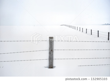 Minimalist Winter Fence Post in Deep Snow with Barbed Wire and Buried Split Rail Fencing Composition Minimalist Winter Fence Post in Deep Snow with Barbed Wire and Buried Split Rail Fencing Composition 132905103