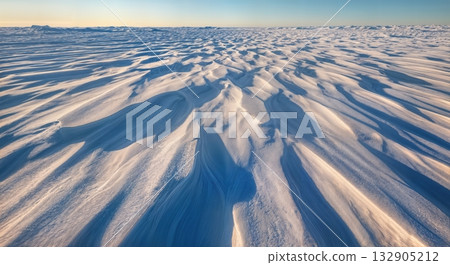 Windswept Snow Formations Sastrugi with Sculptural Ridge Patterns and Strong Side Lighting Creating Dramatic Shadows Windswept Snow Formations Sastrugi with Sculptural Ridge Patterns and Strong Side Lighting Creating Dramatic Shadows 132905212