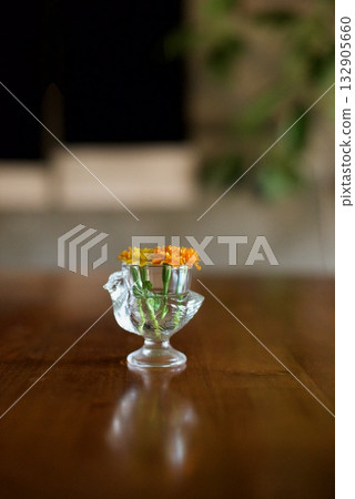 Marigolds in a small glass bird container Marigolds in a small glass bird container 132905660