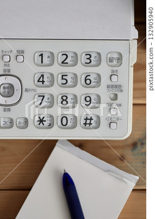 一部老舊骯髒的座機電話，配有傳真機和記事本。按鍵式電話。 132905940