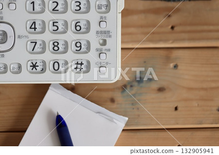 一部老舊骯髒的座機電話，配有傳真機和記事本。按鍵式電話。 132905941