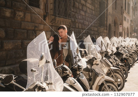 Romantic Couple Sharing a Tender Moment by Scooters Romantic Couple Sharing a Tender Moment by Scooters 132907077