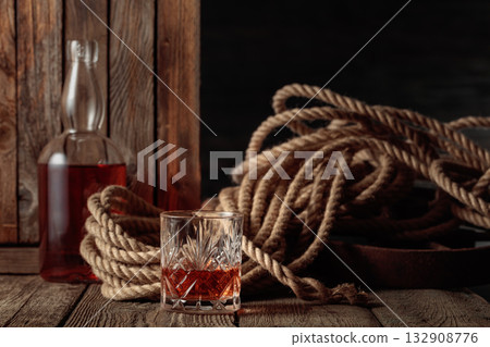 Crystal glass and bottle with rum, cognac, or whiskey. 132908776