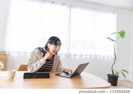 A young woman taking a remote class with an Apple Pencil in hand A young woman taking a remote class with an Apple Pencil in hand 132908888