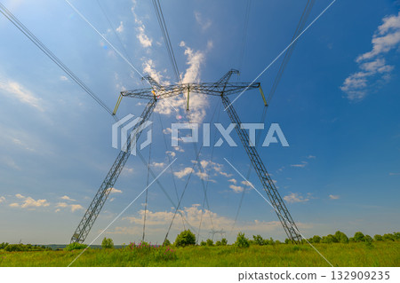 Towering Power Lines Stretch Beneath a Clear Blue Sky, Creating a Stunning Landscape Towering Power Lines Stretch Beneath a Clear Blue Sky, Creating a Stunning Landscape 132909235