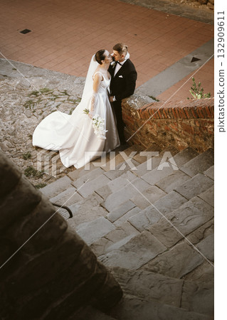 Romantic Wedding Couple Sharing a Kiss on Rustic Steps 132909611