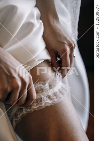 Bride Adjusting Lace Garter on Wedding Day 132909677