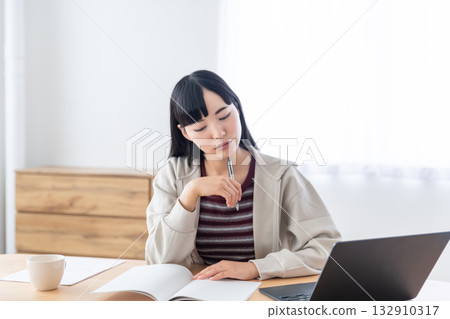 A young woman taking notes during a remote class A young woman taking notes during a remote class 132910317