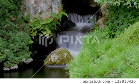Mossy Japanese garden stream and stone bridge 132910426