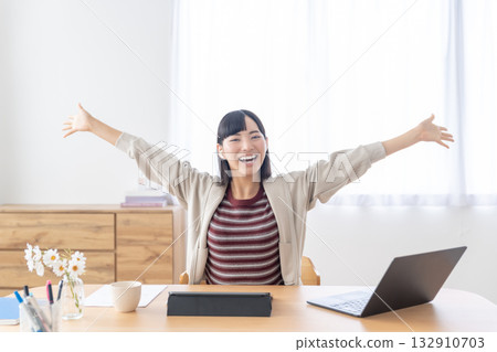 A young woman stretching while sitting in a bright room A young woman stretching while sitting in a bright room 132910703