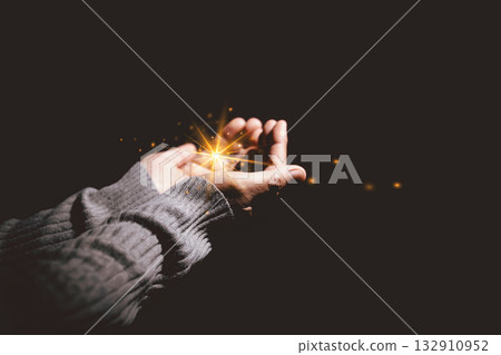 Hands holding glowing light, symbolizing hope, healing, faith, inspiration, spiritual energy, new beginning, miracle, inner strength and positive transformation from darkness to light. 132910952