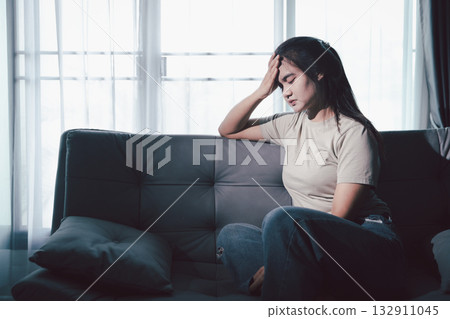 Sorrowful woman sat alone, overwhelmed by emotion, her sad and unhappy expression revealing deep despair, stress and distress left feeling depressed. sorrowful sad, despair alone, depressed stress 132911045