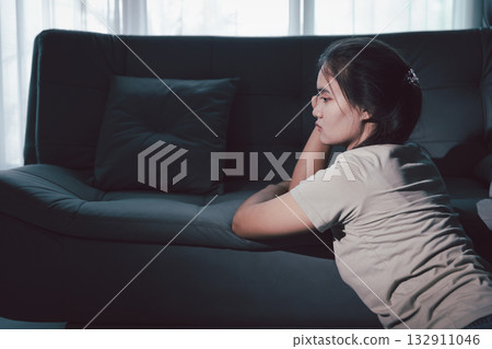 Sorrowful woman sat alone, overwhelmed by emotion, her sad and unhappy expression revealing deep despair, stress and distress left feeling depressed. sorrowful sad, despair alone, depressed stress 132911046