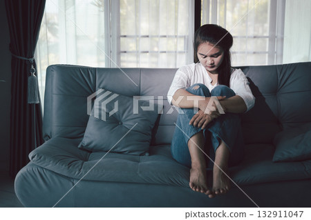 Sorrowful woman sat alone, overwhelmed by emotion, her sad and unhappy expression revealing deep despair, stress and distress left feeling depressed. sorrowful sad, despair alone, depressed stress Sorrowful woman sat alone, overwhelmed by emotion, her sad and unhappy expression revealing deep despair, stress and distress left feeling depressed. sorrowful sad, despair alone, depressed stress 132911047