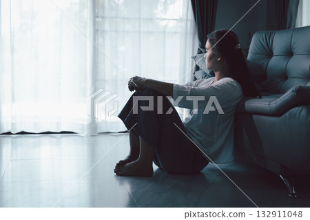Tired depressed desperate tired girl sadly sitting on couch at home. Young woman is sitting on floor living room, feeling sad and depressed. Psychological problem. Depression and loneliness concept. Tired depressed desperate tired girl sadly sitting on couch at home. Young woman is sitting on floor living room, feeling sad and depressed. Psychological problem. Depression and loneliness concept. 132911048