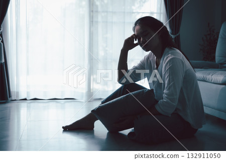 Tired depressed desperate tired girl sadly sitting on couch at home. Young woman is sitting on floor living room, feeling sad and depressed. Psychological problem. Depression and loneliness concept. Tired depressed desperate tired girl sadly sitting on couch at home. Young woman is sitting on floor living room, feeling sad and depressed. Psychological problem. Depression and loneliness concept. 132911050